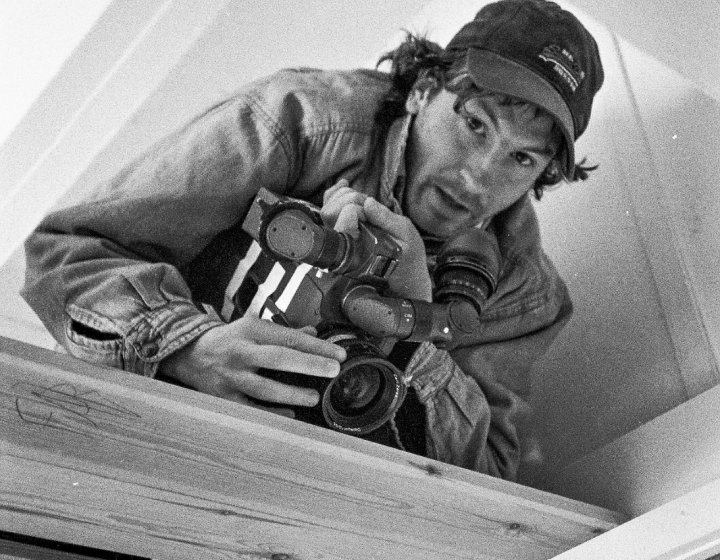 A man wearing a cap and holding a camera