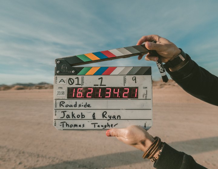 A film slate being held up against an empty field