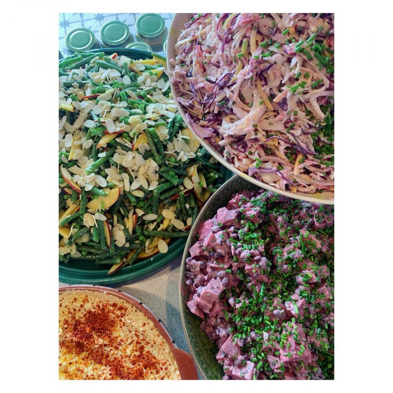 Three colourful salads and a bowl of hummus